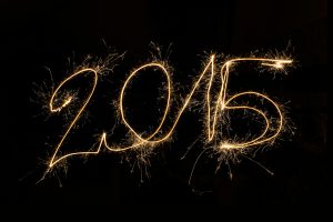 2015 written in sparkler light trails against a dark background, capturing festive celebration.