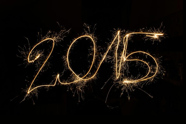 2015 written in sparkler light trails against a dark background, capturing festive celebration.